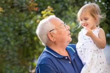 Older man holding his granddaughter