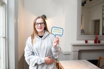 Girl holding up a sign saying 'It starts with you.'