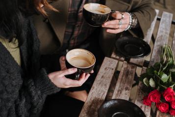 Two friends chatting with a hot coffee