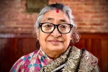 Older lady with glasses smiling at the camera