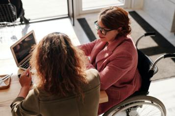 Disabled lady and her carer filling in a survey on the computer