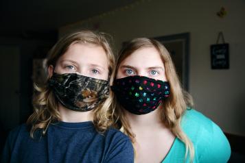 two girls wearing masks