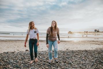 Two ladies chatting on a beach -  end loneliness 