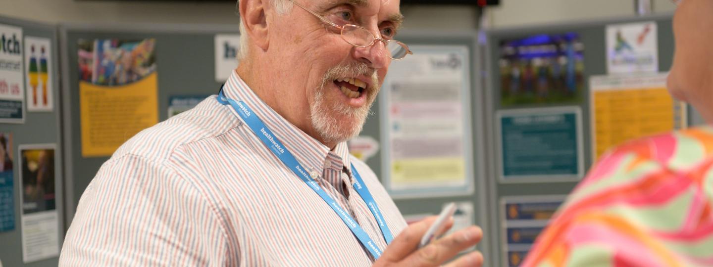 Healthwatch male chatting in public