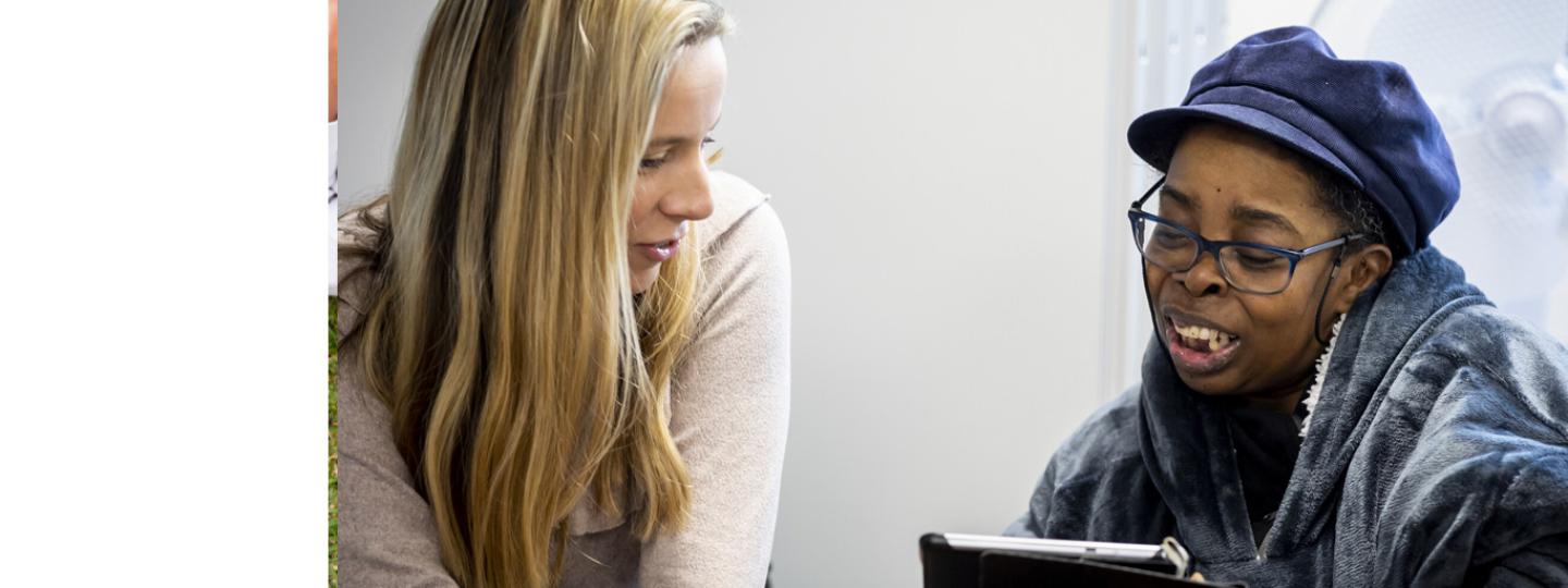 Two ladies talking while looking at a tablet