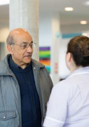 Man standing with staff member in hospital