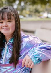 Young woman sitting on bench, smiling