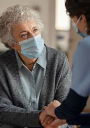 Older lady with face mask on with carer
