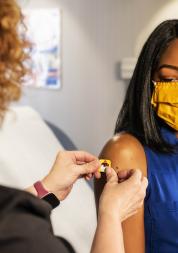 Female having a plaster put on after her vaccination