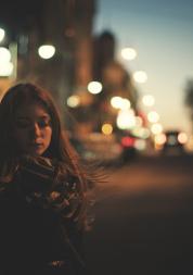 Young woman alone on a street in the dark 