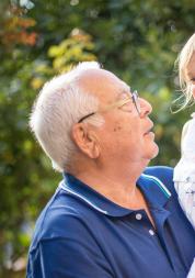 Older man holding his granddaughter