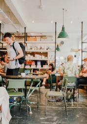 View of a cafe with people sitting and standing while chatting